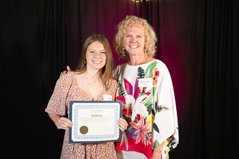 A teenager holding a certificate.