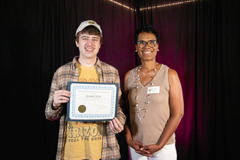A teenager holding a certificate.