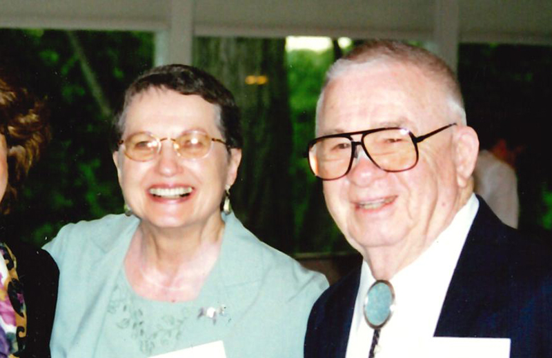 two people sitting next to each other smiling at the camera
