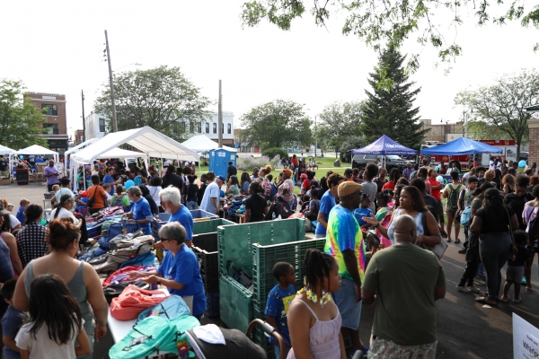 An overview shot of a crowd of people with several canopy tents. 