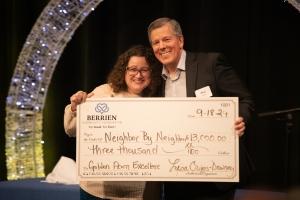 two people standing together holding a larger-than-check.