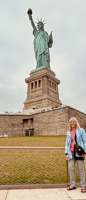 Pam standing in front of the Statue of Liberty.