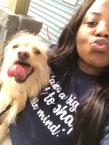 Selfie of Sharnae holding a small dog.