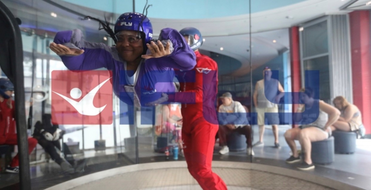 A photo of Sharnae suspended in air in a wind tunnel.